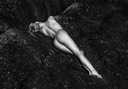 Model Mette Munkø Nude Lying with exposed arse on black rocks TH2013-1131. Foto/Photo: Thomas Holm